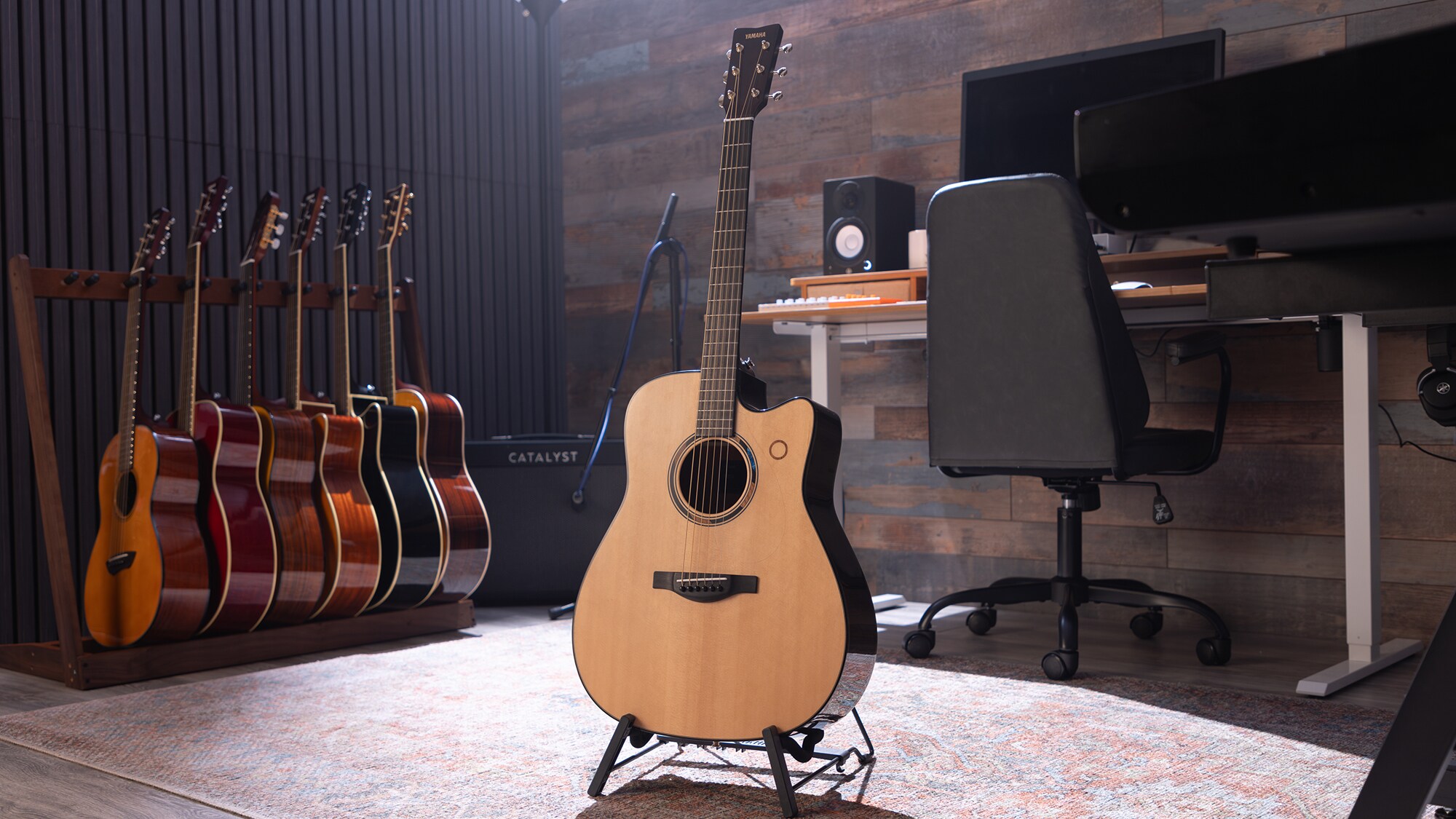 An TAG3 C acoustic guitar placed at the center of a home studio