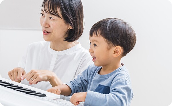 エレクトーンで鍵盤遊びしている子供
