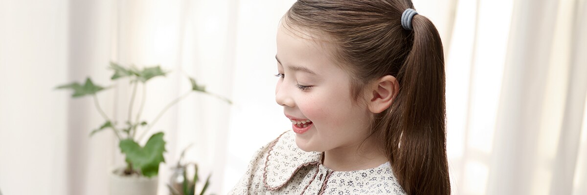 The side profile of a young girl happily playing an ARIUS piano